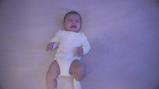 Baby teether with cartoon face design, shown with baby images and text highlighting features.